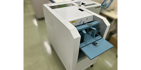 圧着機の写真です。この機械ではがきを圧着します。